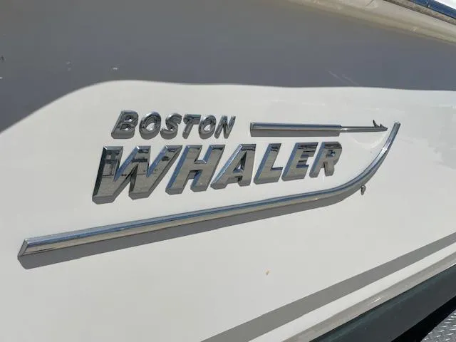 Slide: The Image of Boston Whaler 25' Outrage 2022 boat logo on white hull. - 12