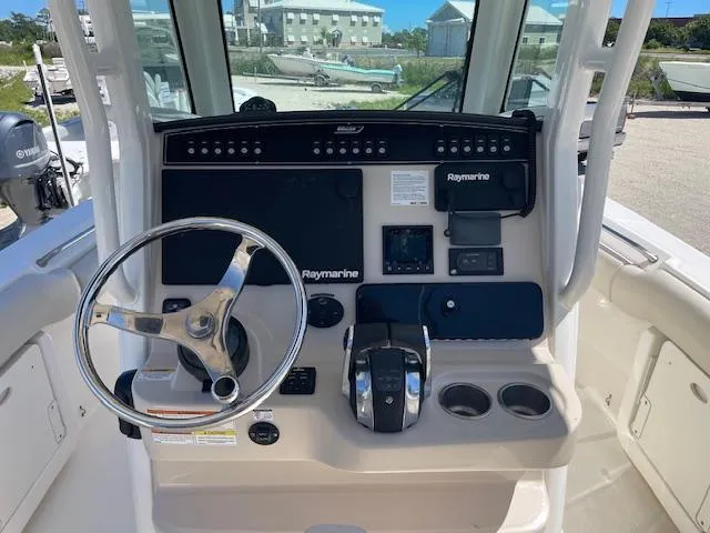 Slide: The Image of 2022 Boston Whaler 25' Outrage boat console with steering wheel and Raymarine electronics. - 13