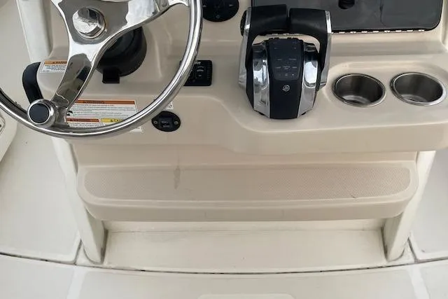 Slide: The Image of 2022 Boston Whaler 25' Outrage helm with steering wheel and controls. - 14