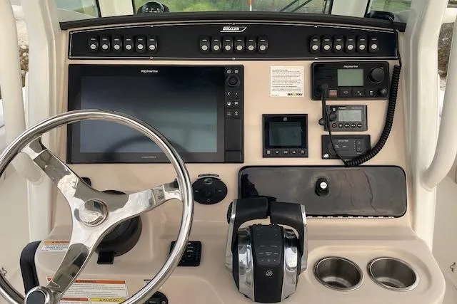Slide: The Image of Control panel of a 2022 Boston Whaler 25' Outrage boat with steering wheel and navigation equipment. - 15