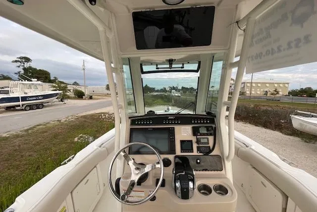 Slide: The Image of 2022 Boston Whaler 25' Outrage boat cockpit with steering wheel and control panel. - 16