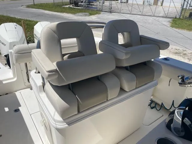 Slide: The Image of 2022 Boston Whaler 25' Outrage boat seats, featuring plush beige upholstery and armrests. - 18
