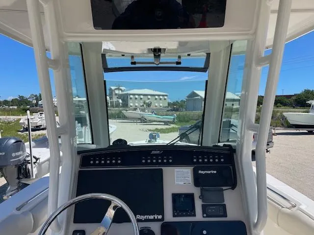 Slide: The Image of 2022 Boston Whaler 25' Outrage boat dashboard with Raymarine electronics, docked outdoors. - 23