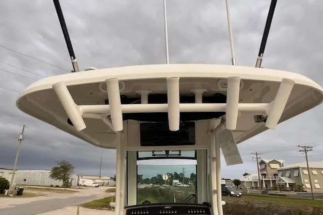 Slide: The Image of 2022 Boston Whaler 25' Outrage boat with rod holders, viewed from below under cloudy skies. - 24