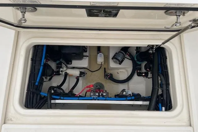 Slide: The Image of 2022 Boston Whaler 25' Outrage boat interior compartment with wiring and components. - 26