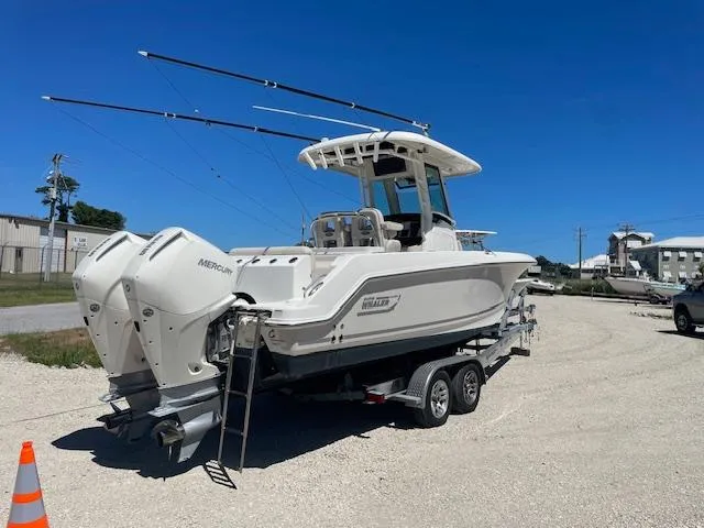 Slide: The Image of 2022 Boston Whaler 25' Outrage boat on trailer, dual engines, parked outdoors. - 3