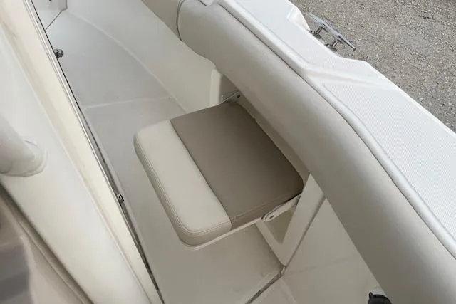 Slide: The Image of 2022 Boston Whaler 25' Outrage boat interior with beige cushioned seating. - 30