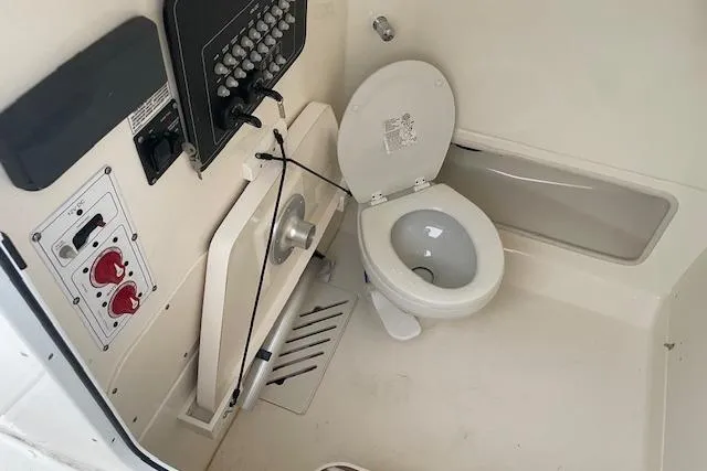 Slide: The Image of Boston Whaler 25' Outrage 2022 boat interior with toilet and control panel. - 31