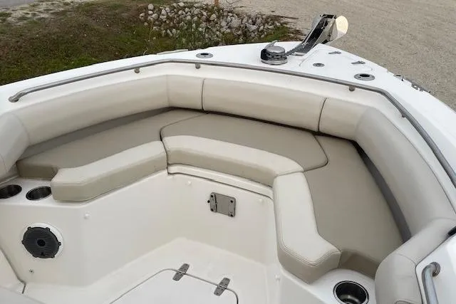 Slide: The Image of 2022 Boston Whaler 25' Outrage boat interior with cushioned seating and cup holders. - 35