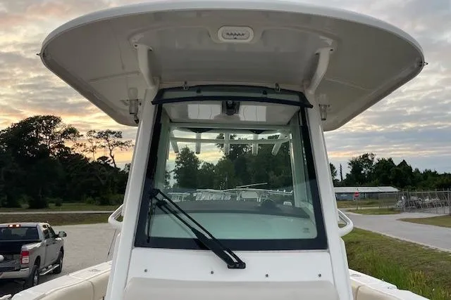 Slide: The Image of 2022 Boston Whaler 25' Outrage boat with windshield and canopy, parked outdoors at sunset. - 36