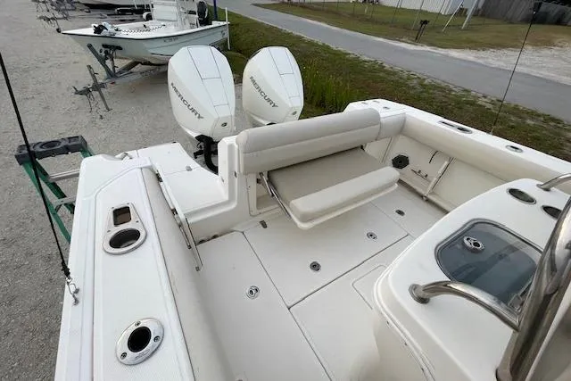 Slide: The Image of 2022 Boston Whaler 25' Outrage boat with dual Mercury engines, spacious deck, and seating area. - 41
