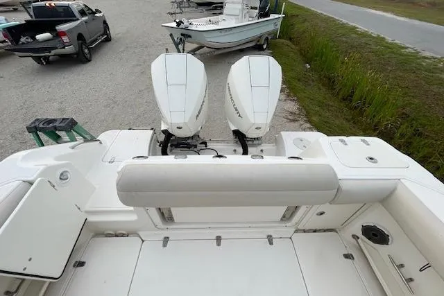 Slide: The Image of 2022 Boston Whaler 25' Outrage boat with dual outboard engines, parked on gravel. - 42