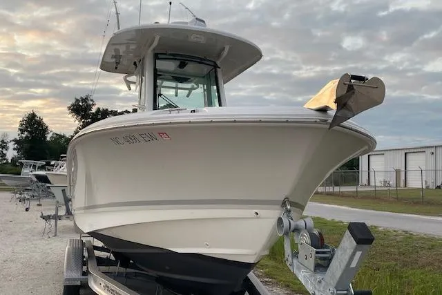 Slide: The Image of 2022 Boston Whaler 25' Outrage boat on trailer, parked outdoors. - 5