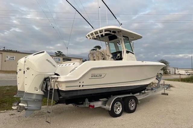 Slide: The Image of 2022 Boston Whaler 25' Outrage boat on trailer, parked outdoors. - 7