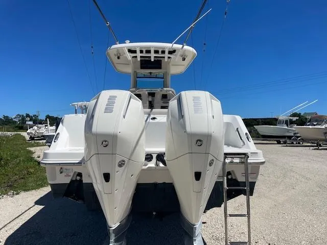 Slide: The Image of 2022 Boston Whaler 25' Outrage boat with dual outboard engines, rear view. - 8