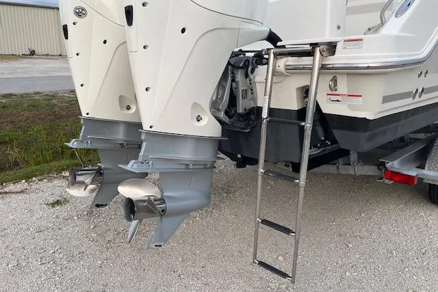 Slide: The Image of Boston Whaler 25' Outrage 2022 with dual outboard motors and a boarding ladder. - 9