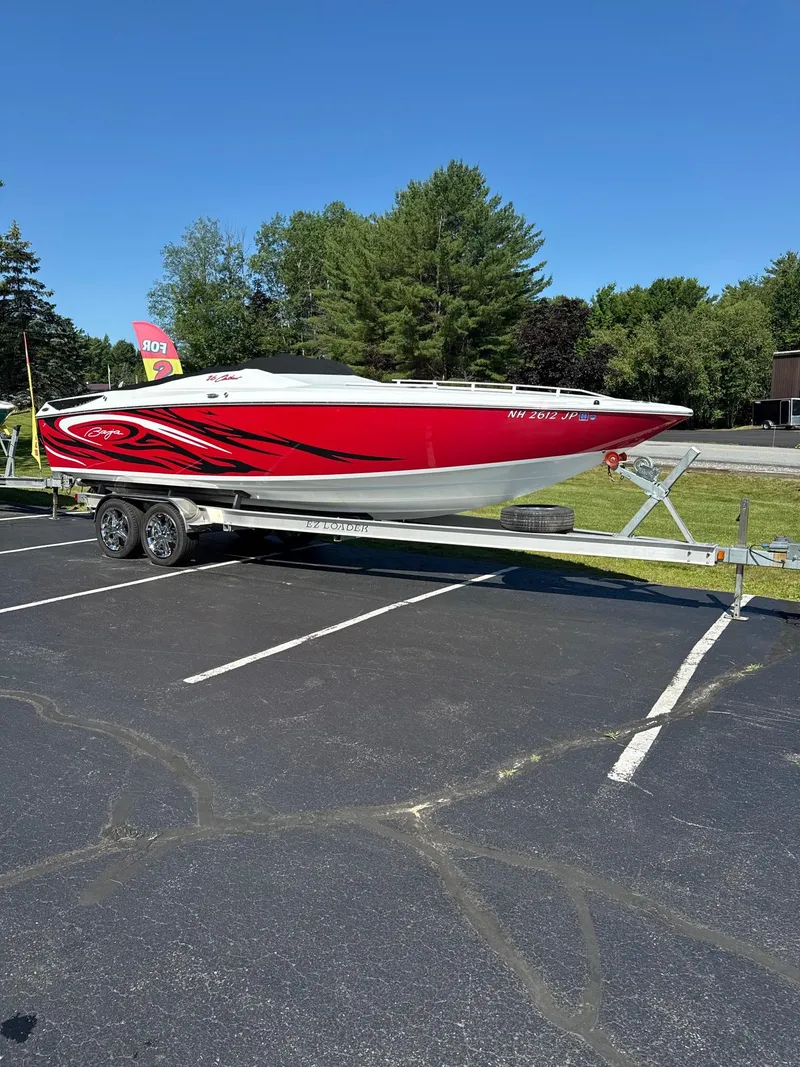 Slide: The Image of 2007 Baja 26 Outlaw boat in red on a trailer, parked in a lot. - 4