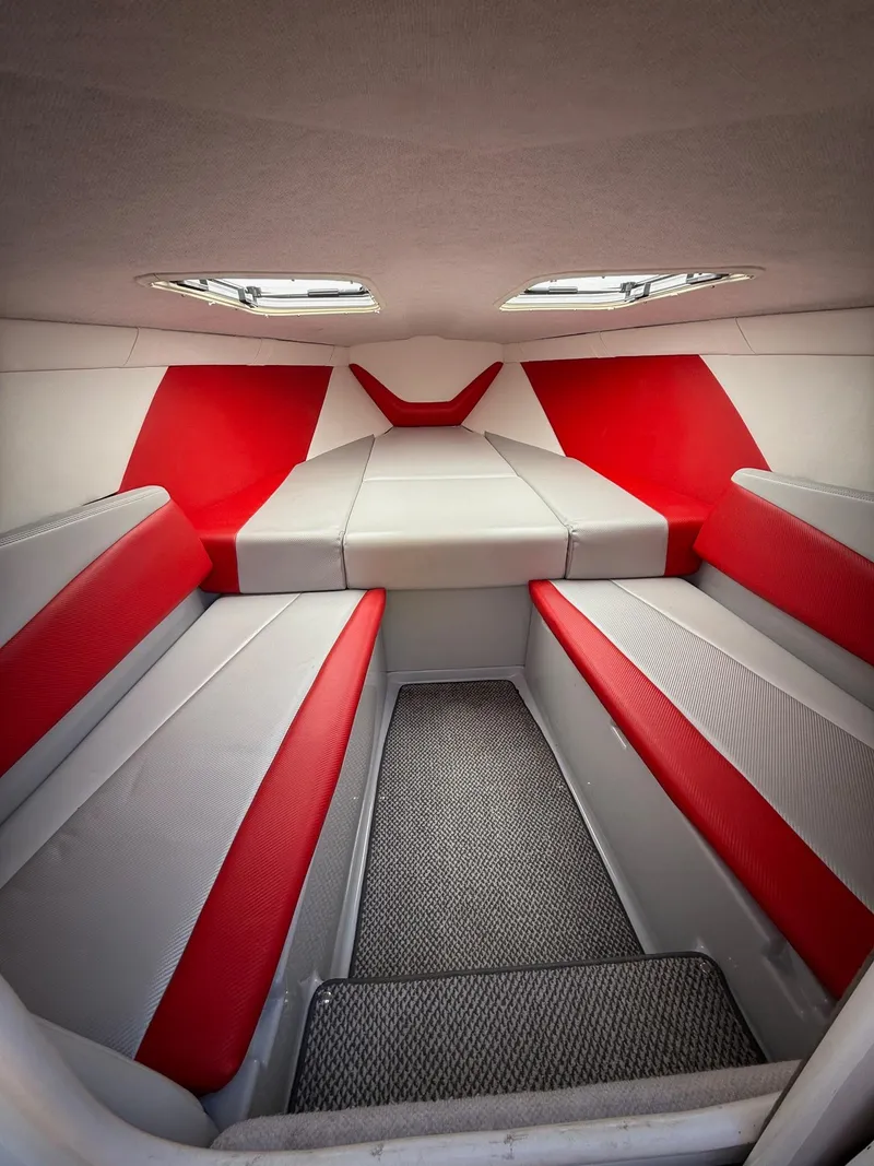 Slide: The Image of 2007 Baja 26 Outlaw cabin interior with red and gray seating. - 7