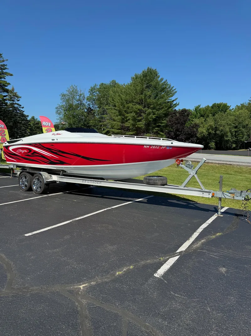 Slide: The Image of 2007 Baja 26 Outlaw boat on trailer, red and white design, parked outdoors. - 8