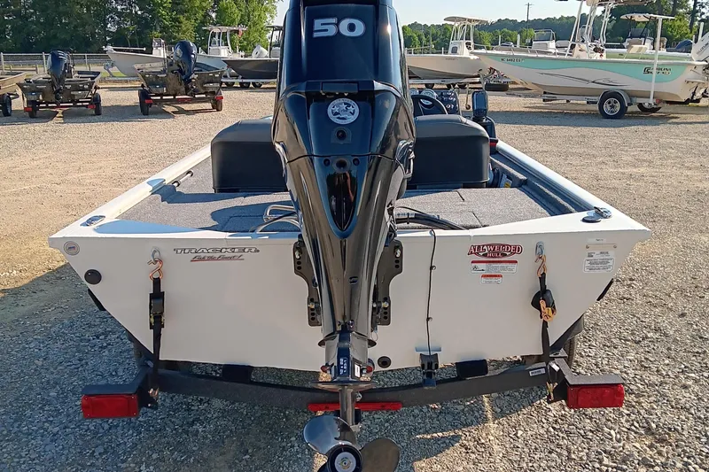 Slide: The Image of 2026 Tracker Pro 170 boat with outboard motor, parked on gravel lot. - 4