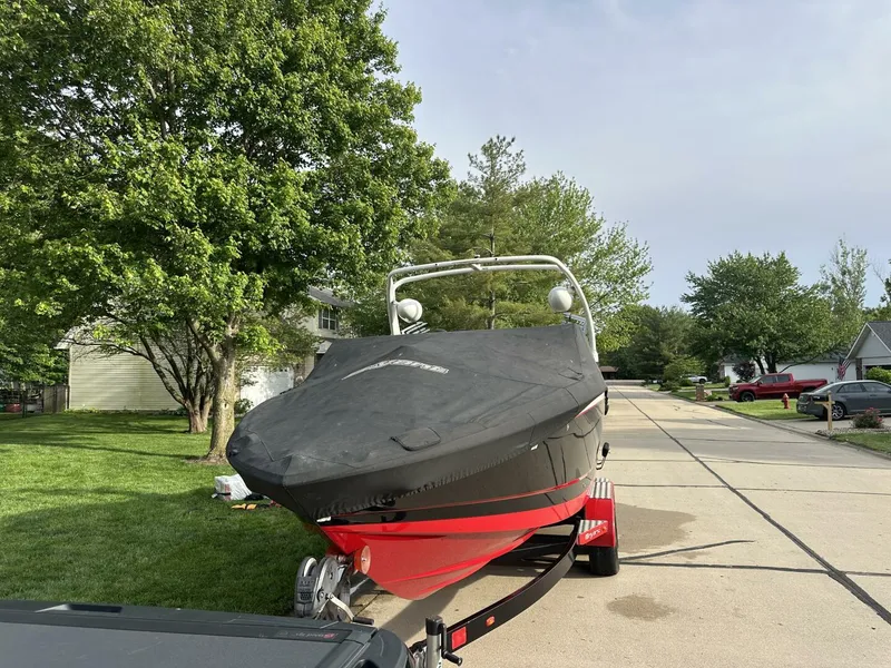 Slide: The Image of 2018 Bryant Calandra 23 boat on trailer, covered, parked in suburban neighborhood. - 9