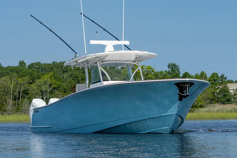 Slide: The Image of 2025 Valhalla Boatworks V-41 in blue, cruising on calm water with fishing rods. - 2