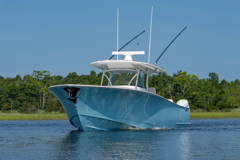 Slide: The Image of 2025 Valhalla Boatworks V-41 in blue, cruising on a serene lake with lush greenery. - 9