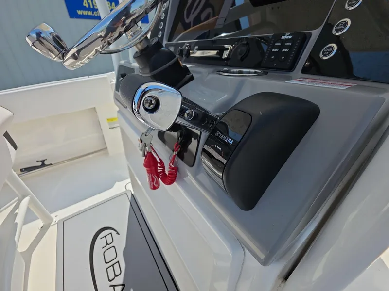 Slide: The Image of 2021 Robalo R242 Center Console boat dashboard with Yamaha controls and steering wheel. - 10