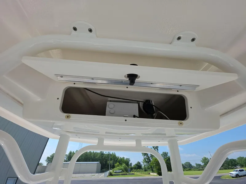 Slide: The Image of 2021 Robalo R242 Center Console storage compartment with open hatch, showing interior wiring. - 11