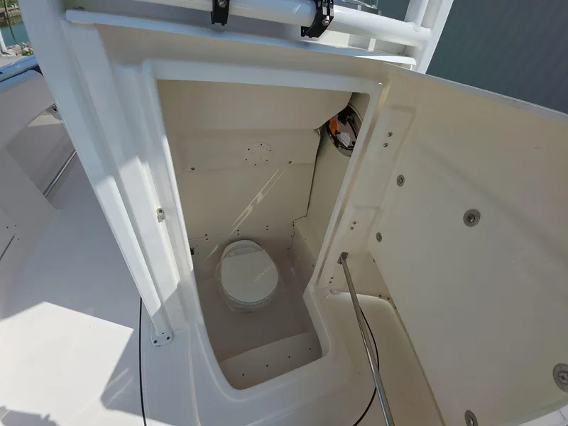 Slide: The Image of 2021 Robalo R242 Center Console boat interior with built-in marine toilet. - 13