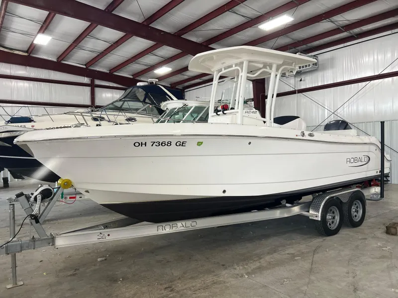 Slide: The Image of 2021 Robalo R242 Center Console boat on trailer in indoor storage facility. - 2