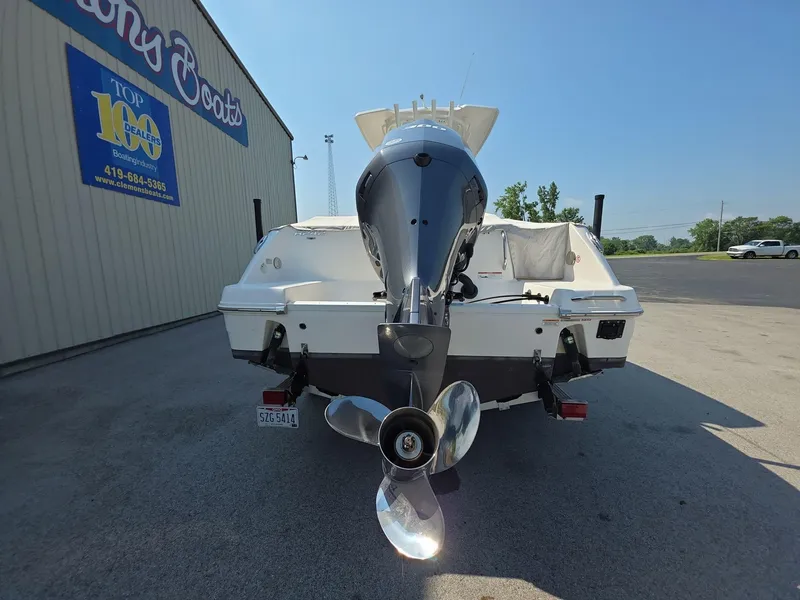 Slide: The Image of 2021 Robalo R242 Center Console boat with outboard motor, parked near a dealership. - 6