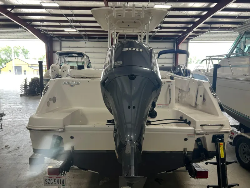 Slide: The Image of 2021 Robalo R242 Center Console boat with 300 HP engine in a storage facility. - 8