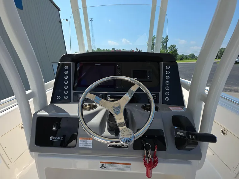 Slide: The Image of 2021 Robalo R242 Center Console boat dashboard with steering wheel and controls. - 9
