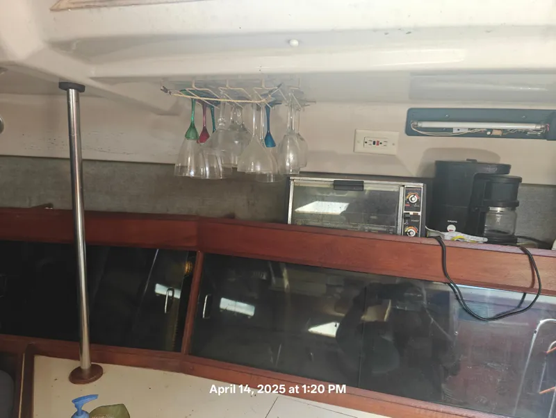 Slide: The Image of Interior of a 1984 Hunter 40 sailboat with kitchen appliances and hanging glasses. - 19