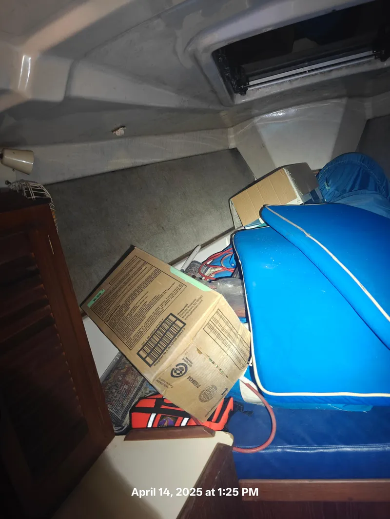 Slide: The Image of Interior of 1984 Hunter 40 sailboat with cushions and boxes, dated April 14, 2025. - 30