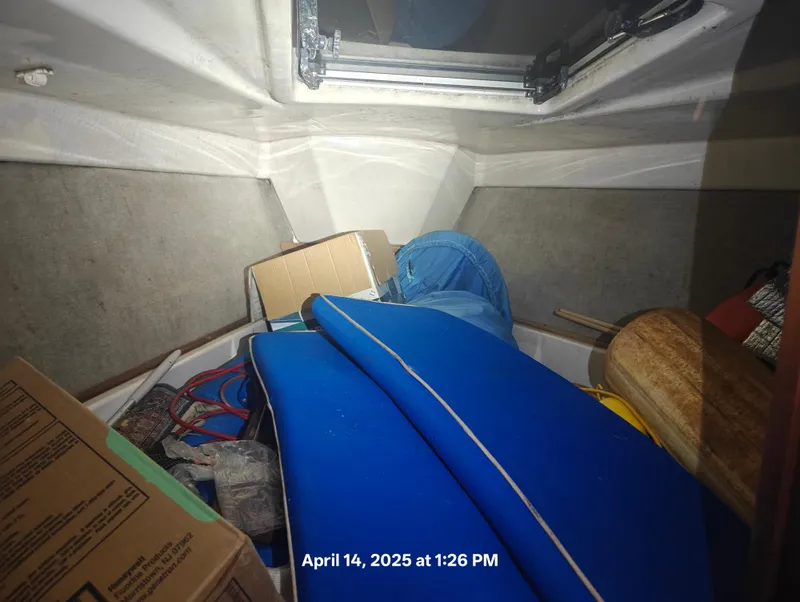 Slide: The Image of Interior of a 1984 Hunter 40 sailboat cabin with stored items and blue cushions. - 31