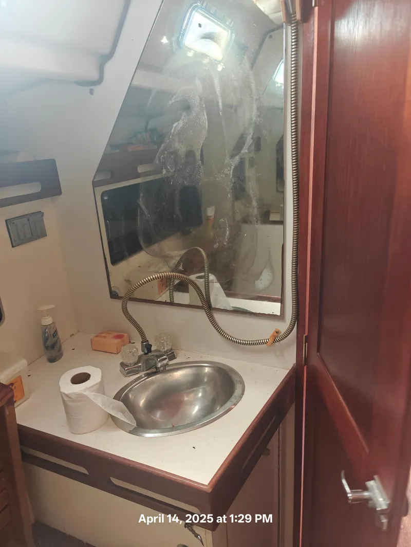 Slide: The Image of Interior of 1984 Hunter 40 boat bathroom with sink, mirror, and toiletries. - 36