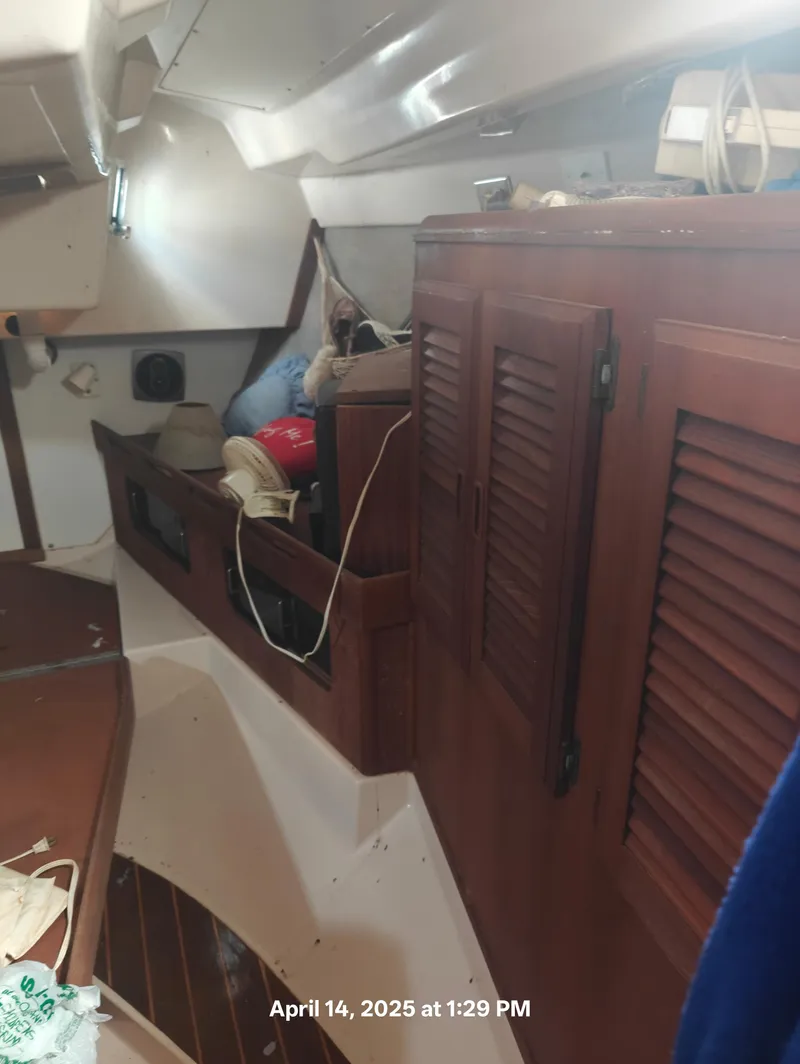 Slide: The Image of Interior of a 1984 Hunter 40 sailboat with wooden cabinets and storage area. - 38