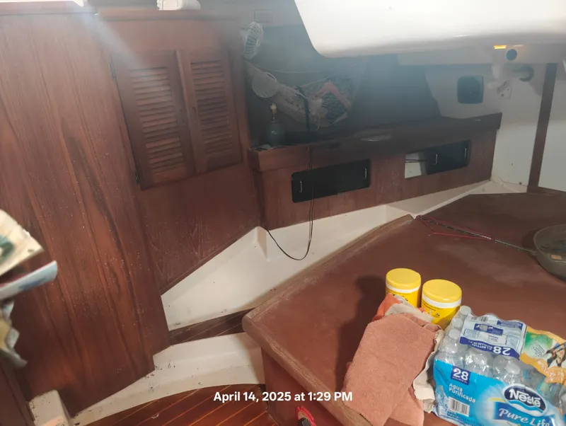 Slide: The Image of Interior of a 1984 Hunter 40 sailboat with wooden cabinets and supplies. - 39