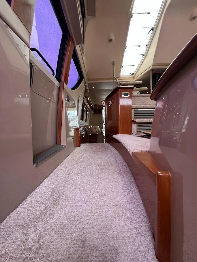 Slide: The Image of Interior of 2006 Carver 56 Voyager yacht, featuring carpeted walkway and wooden accents. - 18