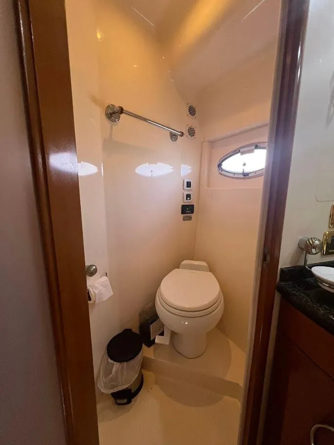 Slide: The Image of Compact bathroom in 2006 Carver 56 Voyager yacht with toilet and porthole window. - 23