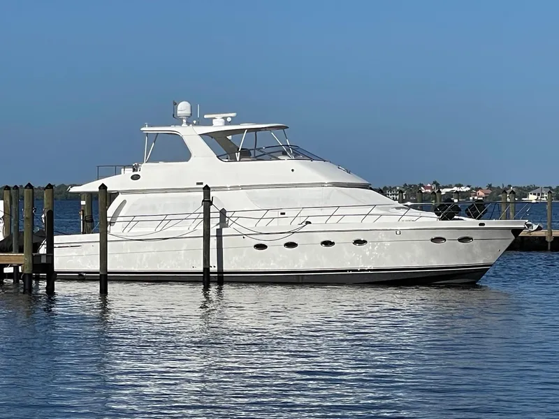 Slide: The Image of 2006 Carver 56 Voyager yacht docked on calm water under clear blue sky. - 3