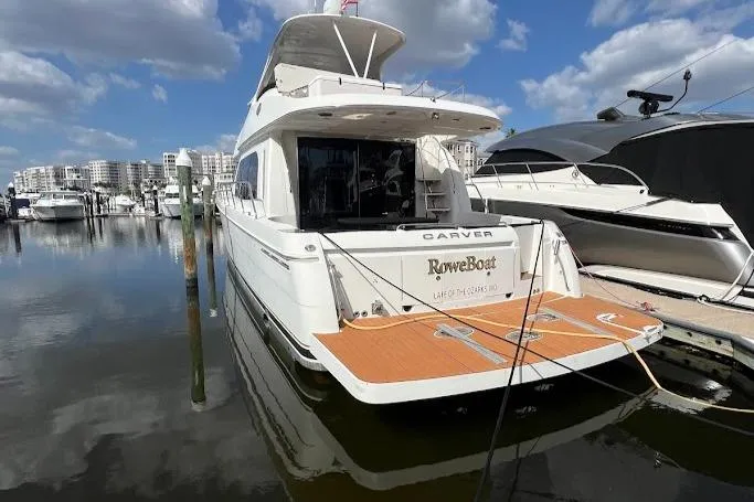 Slide: The Image of 2006 Carver 56 Voyager yacht docked at marina under blue sky. - 34