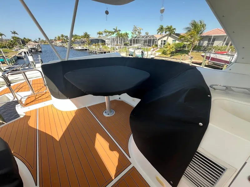Slide: The Image of 2006 Carver 56 Voyager yacht deck with seating, table, and waterfront view. - 35