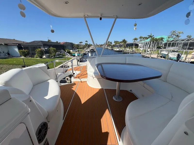 Slide: The Image of Luxurious 2006 Carver 56 Voyager yacht deck with seating and table, overlooking a scenic canal. - 37