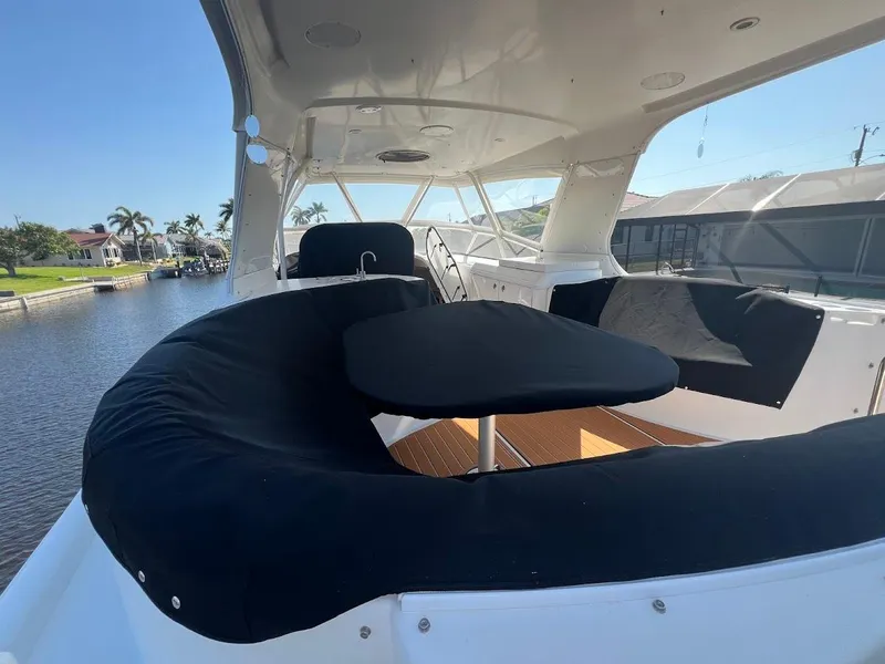 Slide: The Image of 2006 Carver 56 Voyager yacht interior with seating area and table, docked by waterfront homes. - 39