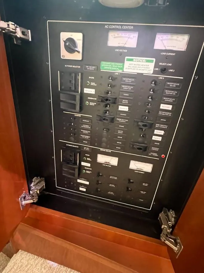 Slide: The Image of AC control panel of a 2006 Carver 56 Voyager yacht, featuring switches and gauges. - 44