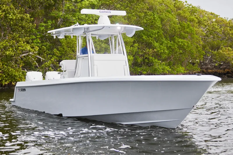 Slide: The Image of 2026 Contender 32 ST boat cruising on water near lush greenery. - 13