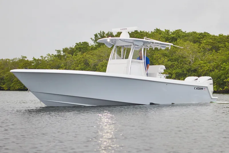 Slide: The Image of 2026 Contender 32 ST boat on calm water, surrounded by lush greenery. - 3